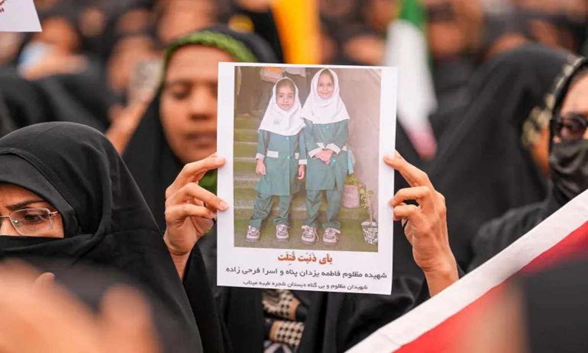 Mourners hold a portrait of a students during a funeral ceremony for children, who lost their lives after a primary school in Iran’s Hormozgan province was targeted in US and Israeli attacks, on March 03, 2026 in Minab, Iran [Anadolu Agency/AlJazeera]